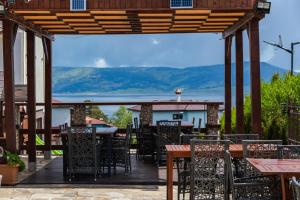 an outdoor patio with tables and chairs with mountains in the background at Family Hotel The View & SPA in Tsigov Chark