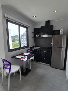 a kitchen with a table and chairs and a refrigerator at Sleek Corner 1 Bed Apt T1-607 in Chalong 
