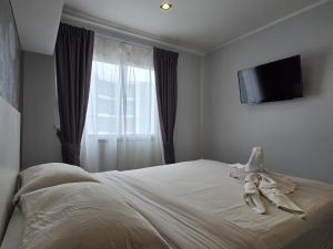 a bedroom with a bed with a television on the wall at Sleek Corner 1 Bed Apt T1-607 in Chalong 