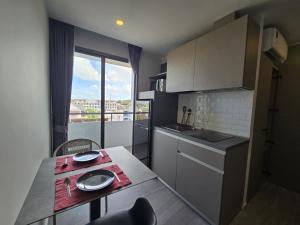 Una pequeña cocina con una mesa y una ventana. en Blue Edge Studio T3-527, en Ban Klang