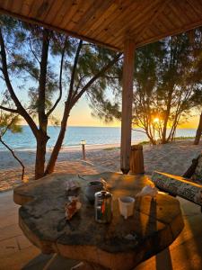a wooden table on the beach with the sunset at Savannah Beach in Ambatomilo +48 photos