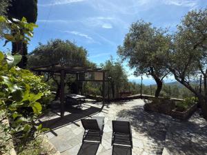 eine Terrasse mit 2 Stühlen, einem Tisch und Bäumen in der Unterkunft Villa Panorama with beautiful private garden in Santa Margherita Ligure