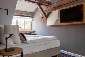 a bedroom with two beds and a flat screen tv at Willa Miłosna in Kwidzyn