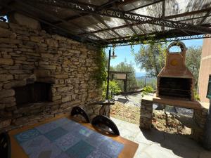 ein Steingebäude mit einem Tisch und einem Kamin in der Unterkunft Villa Panorama with beautiful private garden in Santa Margherita Ligure