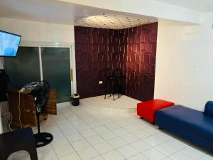 a living room with a couch and a red wall at Mansion Mexicana Private Resort in Calamba