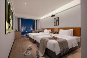 重庆Wuxuan Hotel Zoo Branch的有两张床和一扇窗户的酒店房间