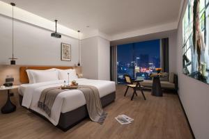 重庆Wuxuan Hotel Zoo Branch的有一张大床和一扇窗户的酒店房间