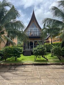 a house with palm trees in front of it at vitamin sea villas in Ko Chang