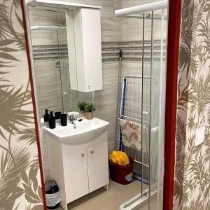 a bathroom with a white sink and a shower at Apartmanház - Delta Kemping in Balatonederics