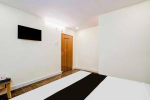 a bedroom with a bed and a tv on the wall at Collection O Neredmet Road in Hyderabad +25 photos