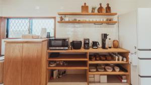 een keuken met houten planken en een magnetron bij 絶景田園と風を感じる癒しの一棟貸しSawah東浪見 in Ichinomiya