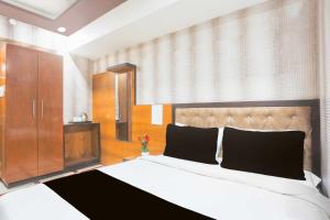 um quarto com uma cama grande e um armário de madeira em Collection O Ajmer Station Road em Ajmer