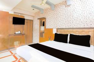 um quarto com uma cama e uma TV na parede em Collection O Ajmer Station Road em Ajmer mais 18 fotografias