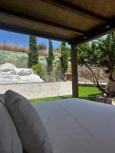 a bedroom with a bed with a view of a garden at Casa Rural en Valera La Egipcia in Valera de Abajo