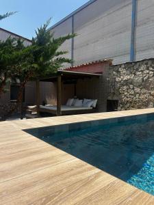 a swimming pool next to a building with a patio at Casa Rural en Valera La Egipcia in Valera de Abajo