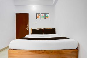 a bedroom with a large bed with white sheets at Collection O Rajeev Nagar in Patna