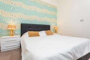 a bedroom with a bed and a wall with clouds at Giulia's Apartment on the sea in Taormina +23 photos
