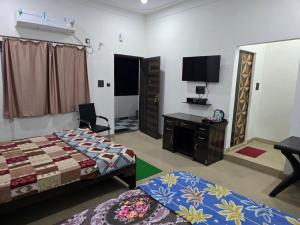 a bedroom with a bed and a tv and a desk at Kaushal Height in Mānpur