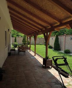 a wooden pergola with benches on a patio at La Perla Apartman 1 in Bela Crkva