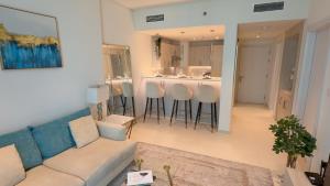 un soggiorno con divano e un bar con sgabelli. di Highend Luxury 7 Palm Residence in Palm Jumeriah a Dubai
