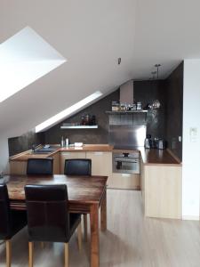 a kitchen with a wooden table and a dining room at Podkrovný apartmán v Smokovec in Smokovce