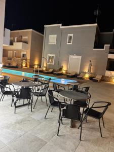 a group of tables and chairs in front of a pool at Diamond Deluxe Apartments Pool&Bar in Mastichari