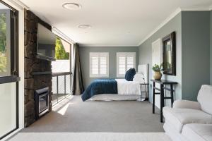 a bedroom with a bed and a tv and a couch at Kaitahi Lodge in Palmerston North
