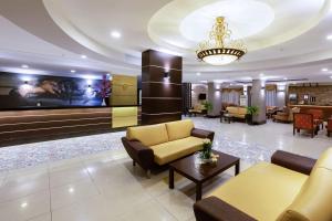 a lobby with couches and a television and a chandelier at Mysea Hotels Incekum - All Inclusive in Avsallar