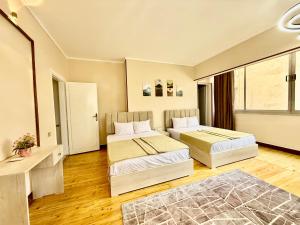 Una habitación de hotel con dos camas y una ventana. en La Casa del Centro Cairo, en El Cairo