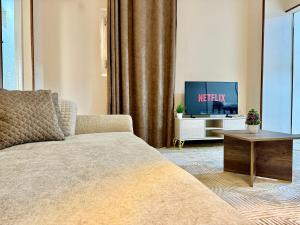 Una sala de estar con una cama y un televisor. en La Casa del Centro Cairo, en El Cairo