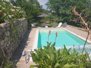 una piscina en un patio con una pared de piedra en chez Marcel, en Rosières 11 fotos más