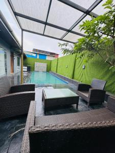 肯达拉VG09 with huge Pool and bathtub的一个带椅子和桌子的游泳池以及绿色的墙壁