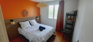 a bedroom with a bed with an orange wall at Le Balcon de Cournon, piscine, jardin, clim à 15 min de plages in Cournonterral +31 photos