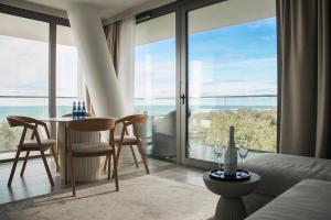 a living room with a table and chairs and a large window at Privilege Apartment in Międzyzdroje