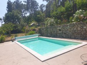 a swimming pool in front of a stone wall at chez Marcel in Rosières +14 photos