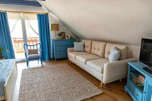 a living room with a couch and a tv at Vitorlás Vendégház Balatonalmádi in Balatonalmádi