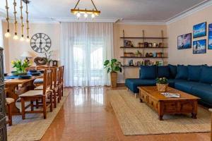 a living room with a blue couch and a table at Vitorlás Vendégház Balatonalmádi in Balatonalmádi