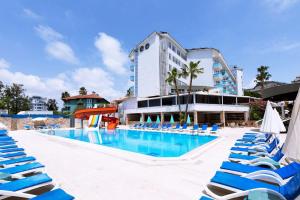 a swimming pool with blue lounge chairs and a hotel at Mysea Hotels Incekum - All Inclusive in Avsallar