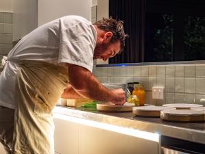 a man standing in a kitchen preparing food at Kaitahi Lodge in Palmerston North