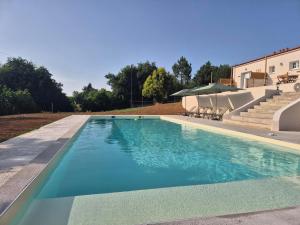 a swimming pool with chairs and stairs next to a building at Casa Abuela, L'hacienda de Soubran, classé 4 étoiles in Soubran