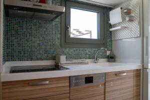 una cocina con fregadero y ventana en Eclectic Urban Nest, en Heraklion