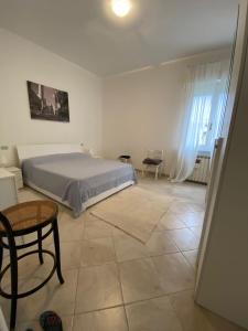 a bedroom with a bed and a table and a chair at delizioso appartamento vicinissimo al mare in Marina di Massa