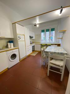 a kitchen with a table and a washing machine at delizioso appartamento vicinissimo al mare in Marina di Massa