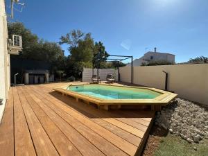 a swimming pool on a wooden deck at Oasis privee a Vendres piscine et confort moderne in Vendres