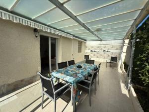 a patio with a table and chairs on a balcony at Oasis privee a Vendres piscine et confort moderne in Vendres +18 photos