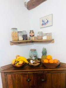 a wooden cabinet with bowls of fruit on it at San Vicente de Robres in San Vicente