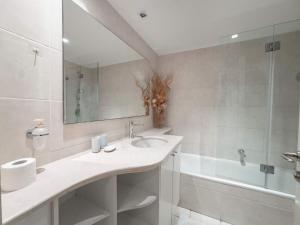 a bathroom with a sink and a tub and a mirror at Breeze Suite at The Island in Herzliya B