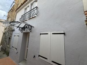 a building with white doors and a light on it at Maison de Village Portiragnes in Portiragnes