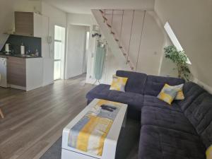 a living room with a purple couch and a table at Ferienwohnung in Schonwald im Schwarzwald +8 photos