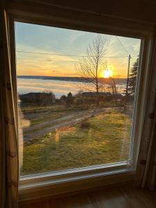 a window with a view of the sunset at Cabin with great view close to town and ski area in Lillehammer